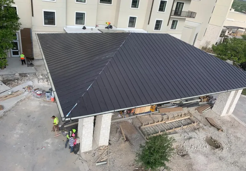 Metal roofing installation team working on a commercial building in Madras